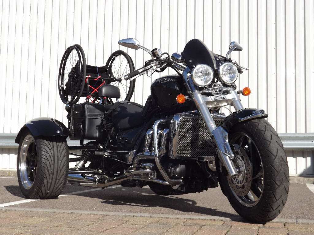 Casarva Rocket 111 trike with disability adaptations. Reverse gearbox, raked front forks to make steering lighter, rigid frame wheelchair rack, Kliktronic gear shifter, K Lever2 twin brake levers, Footplates with back stops and velcro straps, Lap belt, reupholstered seat with special foam insert.
